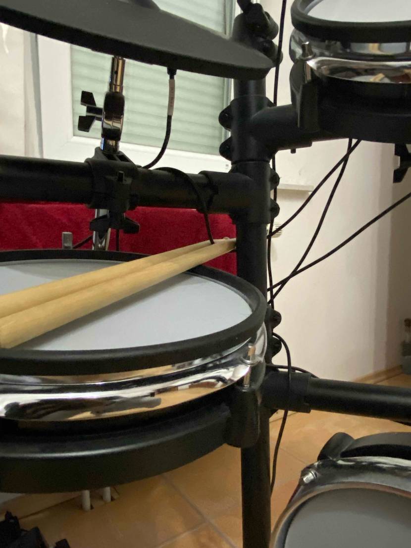 Ein E-Drums-Set im Test: Drumsticks liegen auf einem Drumpad.