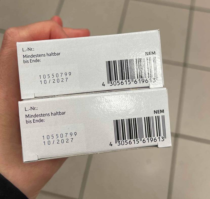 Eine Hand hält zwei Packungen getestete Eisentabletten mit der Unterseite nach oben, auf der das MHD steht.