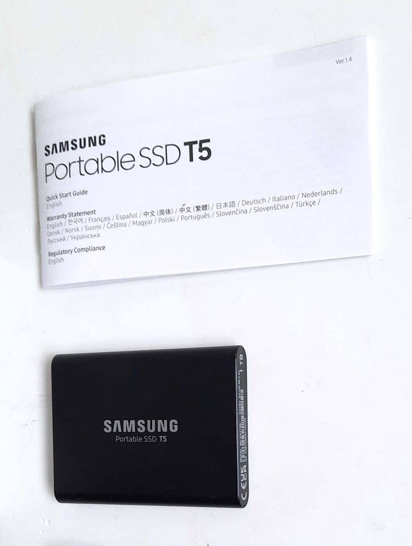 Im Test: Eine Externe SSD-Festplatte unterhalb der Bedienungsanleitung auf einer hellen Fläche.