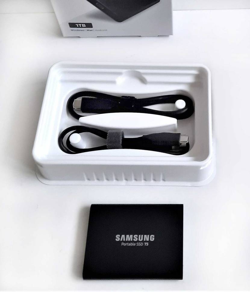 Externe SSD-Festplatte getestet: Ein Gerät vor seiner geöffneten Verpackung in der Kabel liegen.