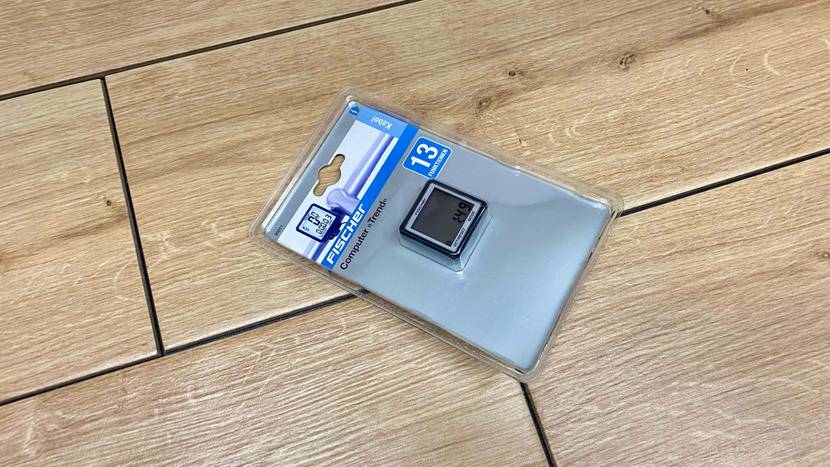 Im Test: Ein Fahrradcomputer in der Originalverpackung auf einem Holzboden.