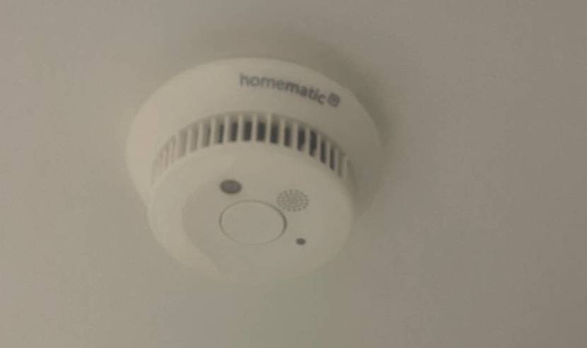 Weißer Homematic Funk-Rauchmelder im Test befindet sich von unten betrachtet an einer weißen Decke.