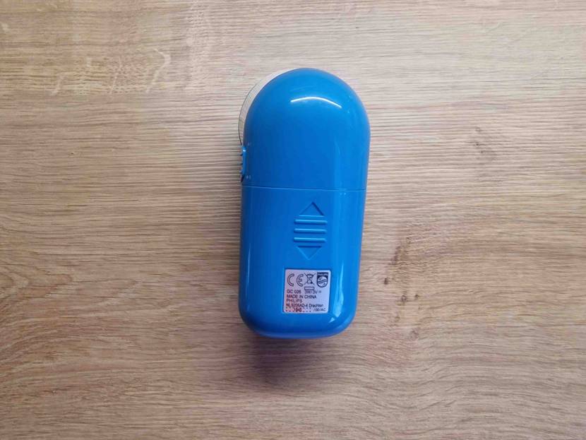 Im Test: Ein Fusselrasierer mit der Rückseite nach oben auf einer Holzfläche.