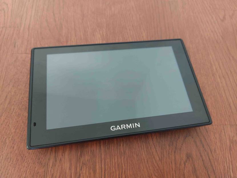 Garmin Navi getestet: ein Gerät liegt ausgeschaltet mit Display nach oben auf dunklem Boden.