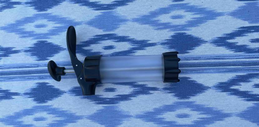 Gebäckpresse im Test liegt quer auf blau-gemusterter Fläche.