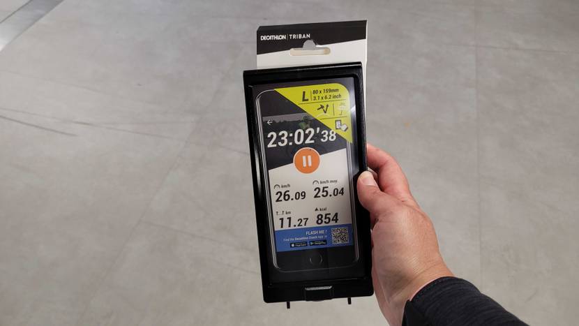 Handyhalterung-Fahrrad getestet: Eine Hand hält eine verpackte Halterung vor einen grauen Boden.