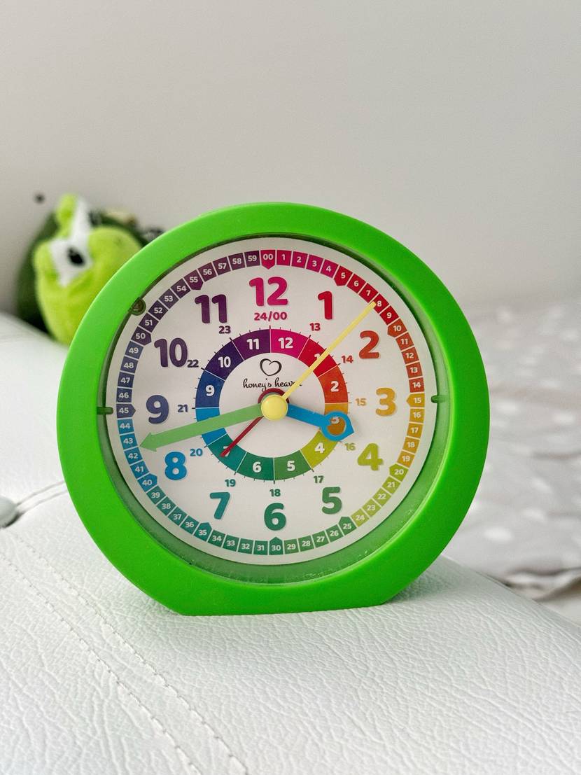 Getestet: Ein bunter Kinderwecker steht auf einem weißen Regal.