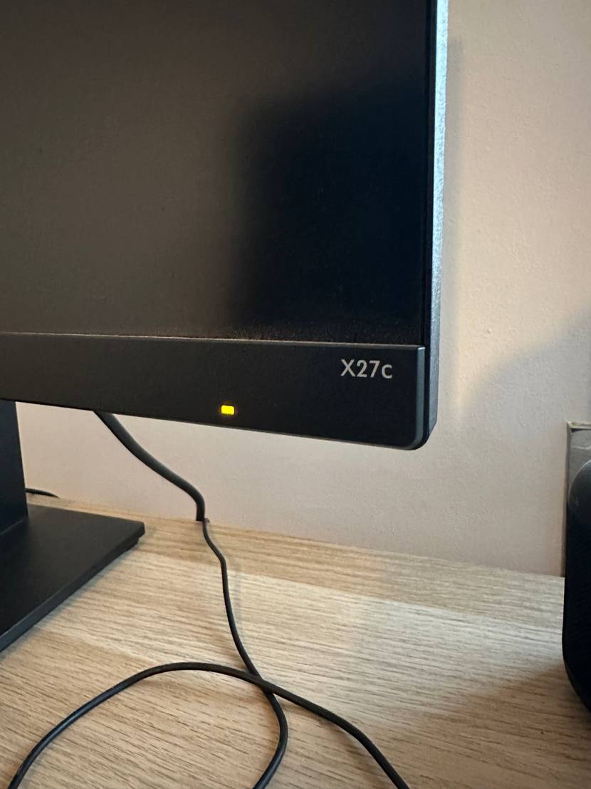 Detailansicht der rechten unteren Ecke mit Betriebsleuchte und Modelangabe eines getesteten Curved Monitors.