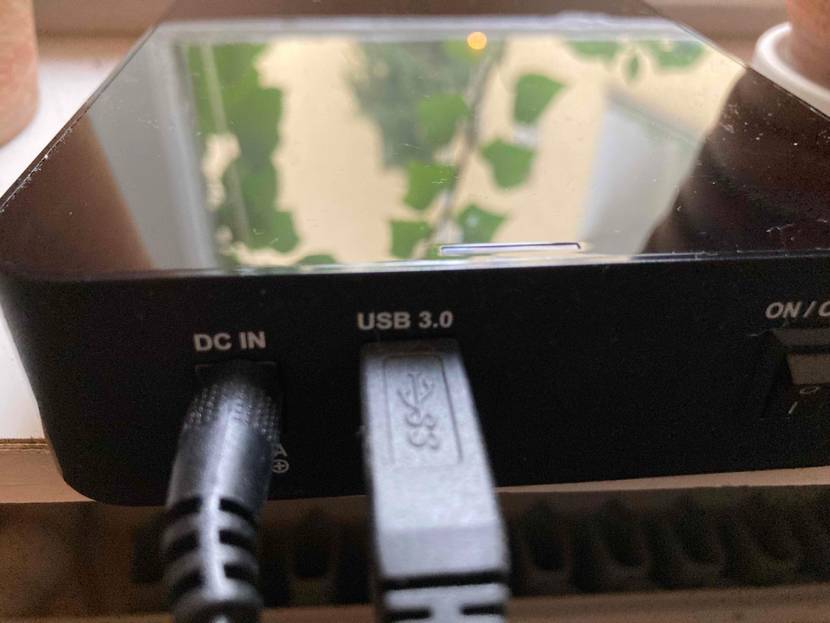Detailansicht einer getesteten 8-TB-Festplatte in Schwarz: DC IN sowie USB 3.0 Anschlüsse inklusive eingesteckter Kabel.