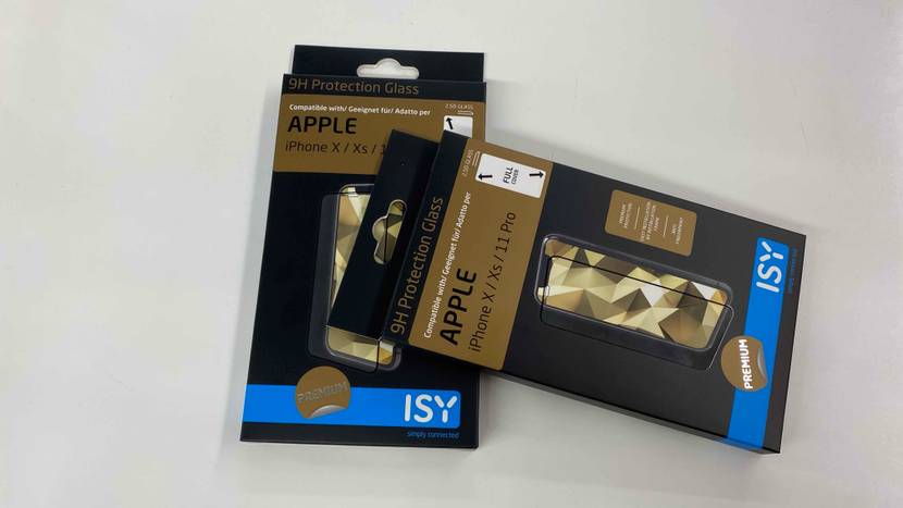 Zwei Verpackungen von iPhone-X-Panzerfolien im Test liegen zusammen auf einer hellen Fläche.