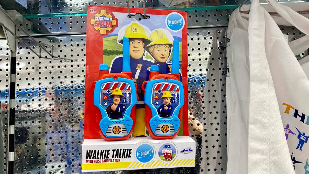 Eine Verpackung mit zwei getesteten Walkie-Talkies für Kinder im Feuerwehrmann-Design hängt an einem Verkaufsregal.
