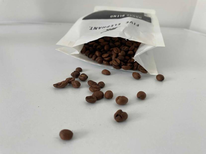 Geöffnete Packung mit Kaffeebohnen auf Tisch