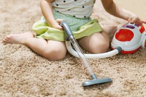 kind mit kleinem kinderstaubsauger