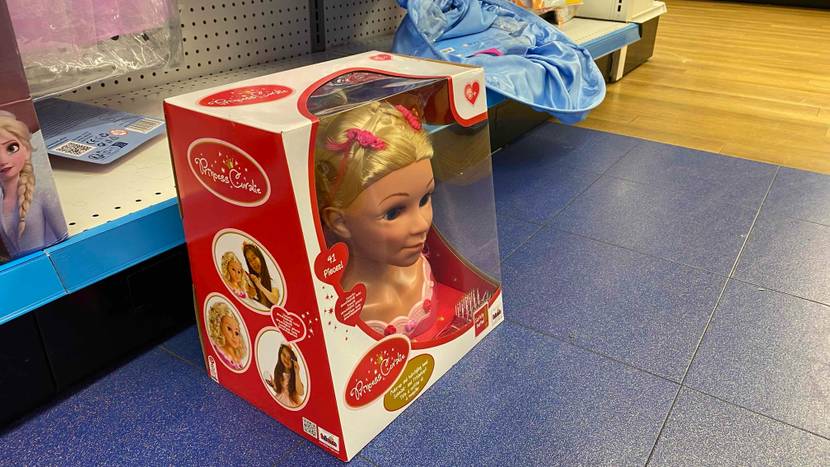 Getestet: Schminkpuppe-Puppenkopf Princess Coralie befindet sich in der Originalverpackung mit Sichtfenster vor einem Verkaufsregal.