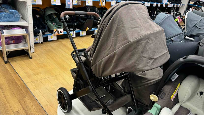 Ein getesteter Kombikinderwagen von schräg hinten mit geschlosssenem Verdeck in einer Verkaufsfläche.