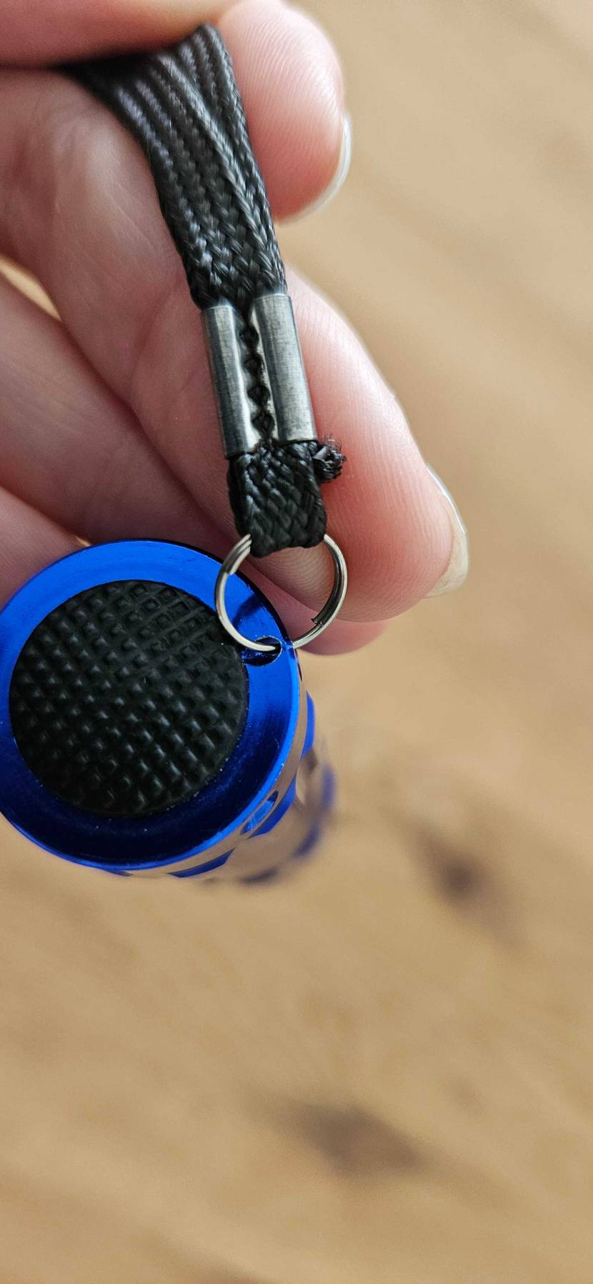 LED-Taschenlampe getestet: Eine Hand hält die Rückseite mit Einschaltknopf hoch.