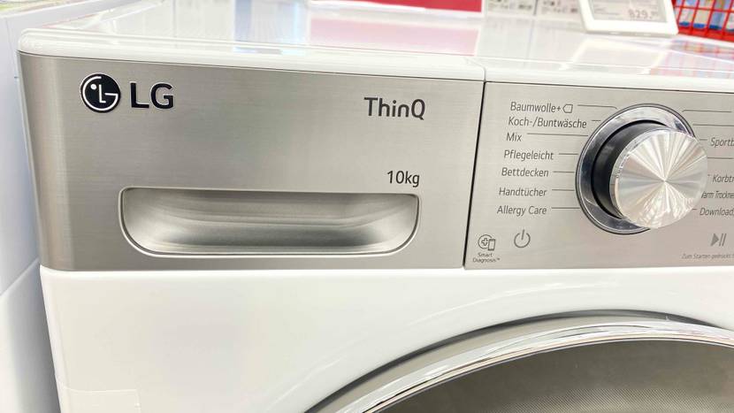 Detailansicht der metallfarbenen Waschpulver-Schublade und des Programmreglers eines LG, Thin Q 10 kg, Wärmepumpentrockners im Test.