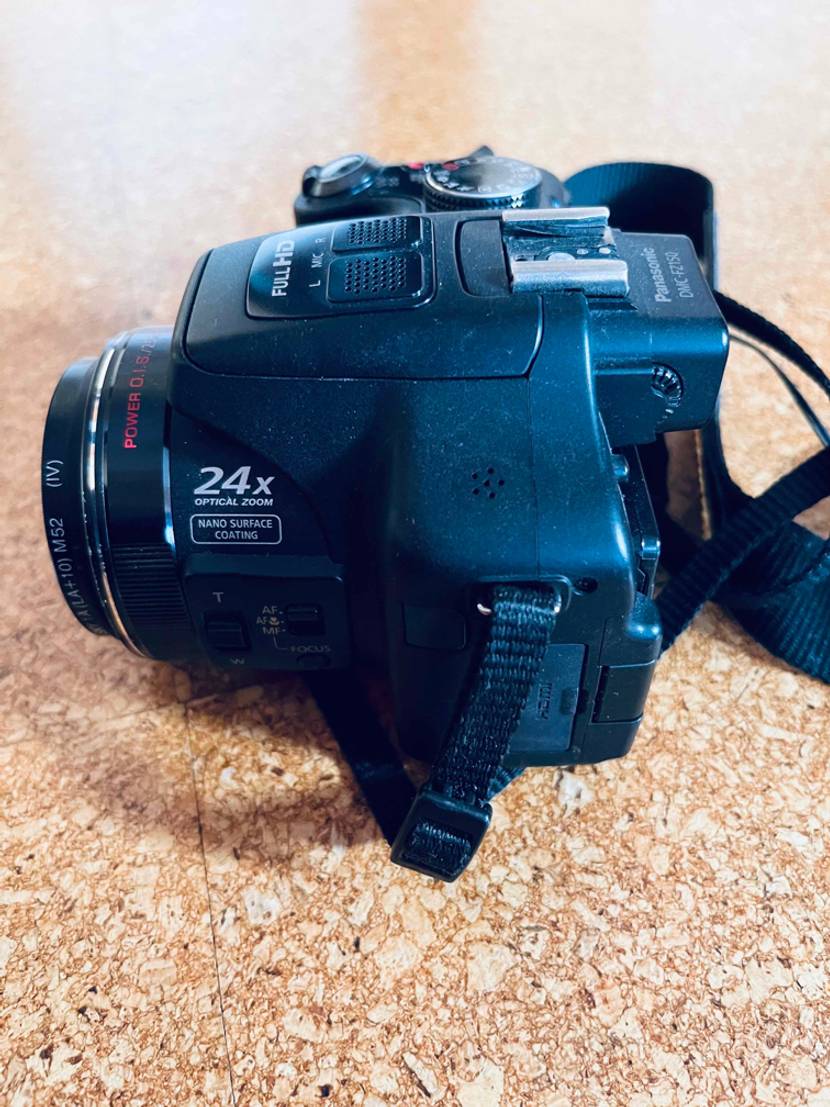 Seitliche Draufsicht einer Digitalkamera im Test: 24x Optical Zoom Modell von Panasonic auf einer Korkunterlage.