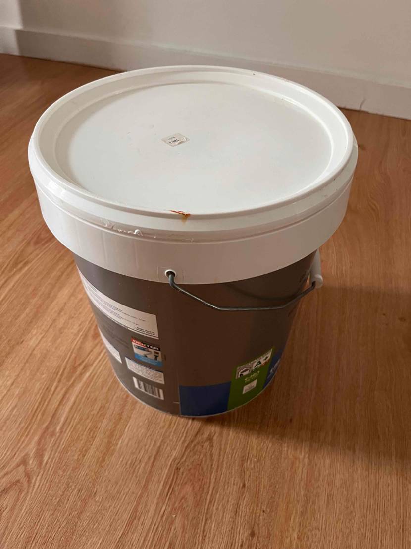 Getestete Wandfarben: Deckel-und Rückseitenansicht von oben eines Eimers, der in einem Zimmer steht.