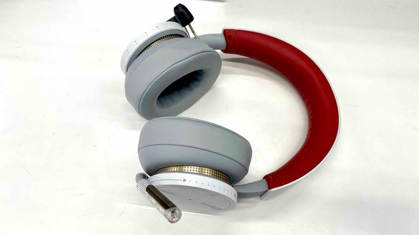 Ein Microsoft Bluetooth-Headset im Test liegt auf einer weißen Fläche, mit Fokus auf die gepolsterten Hörmuscheln und den roten Bügel.