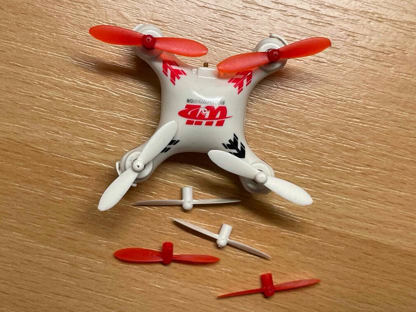 Nahaufnahme des Mini-Quadrocopter von oben auf einer Holzfläche.