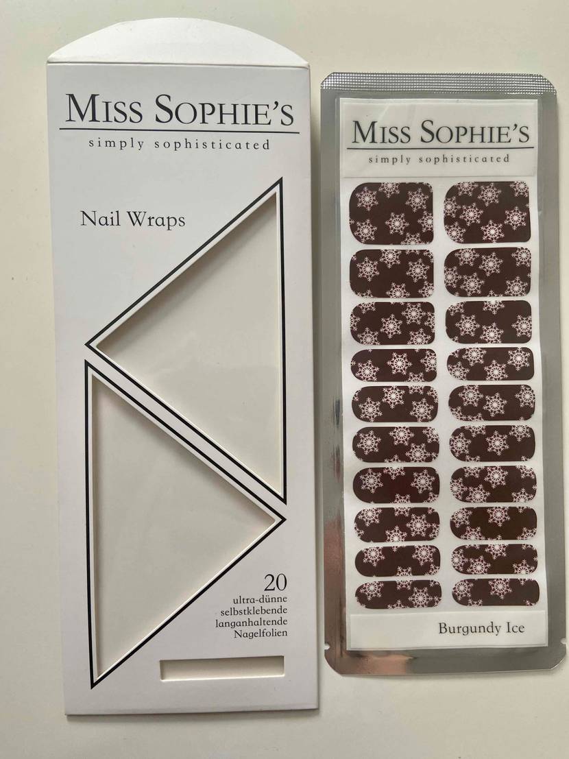 Ausgepackter Blister einer getesteten Nagelfolie von Miss Sophie's liegt neben Verpackung auf weißer Fläche.
