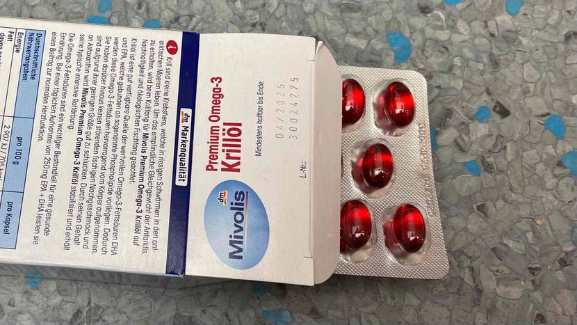 Krillöl im Test: Blister mit Kapseln schaut aus einer geöffneten Packung von Mivolis, die mit der Rückseite nach oben liegt.