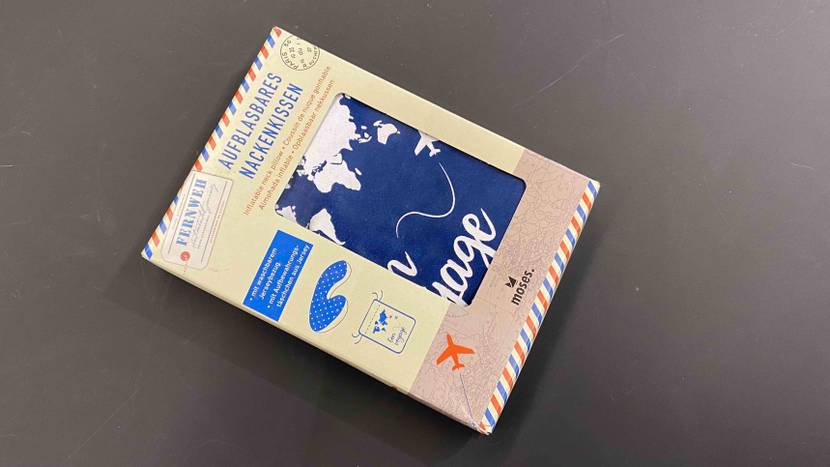 Ein aufblasbares Moses Nackenkissen im Test befindet sich in seiner Originalverpackung auf einer grauen Fläche