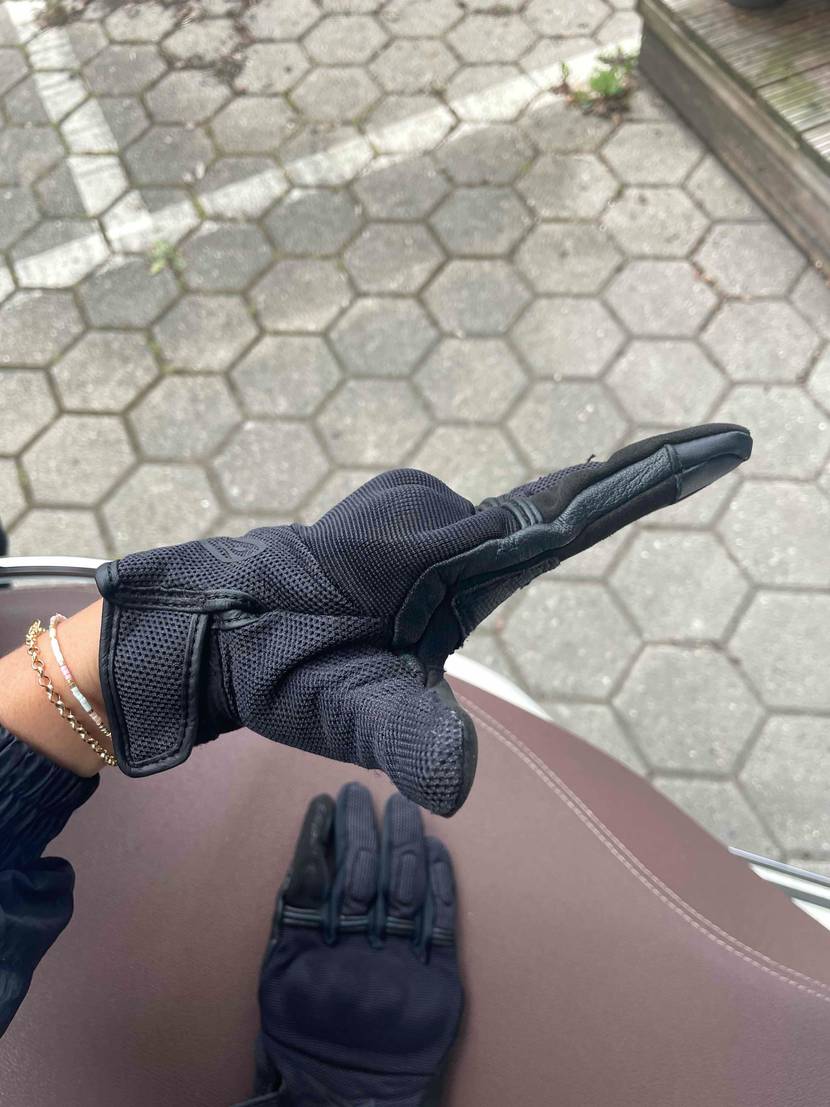 Eine Hand mit dem getesteten Motorradhandschuh spreizt Zeigefinger und Daumen.