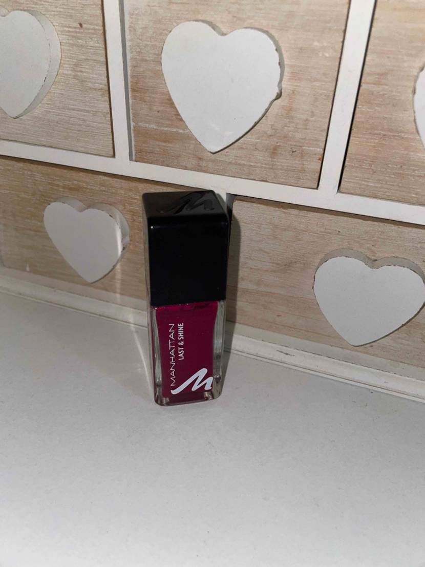 Getesteter Nagellack auf einer Ablage mit Herzfliesen im Hintergrund.
