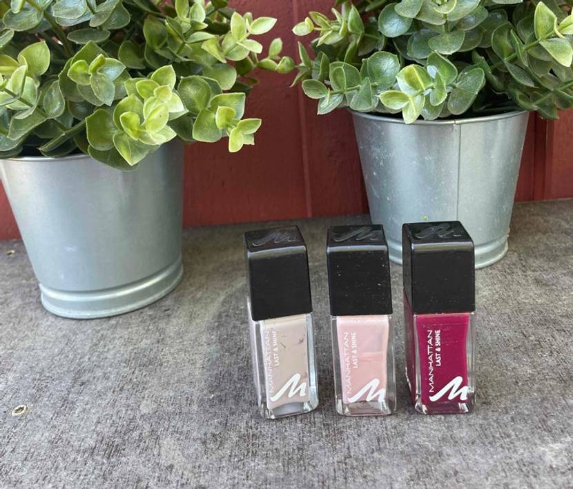 Nagellack im Test: Drei verschiedene Nagellacke mit Pflanzen im Hintergrund.