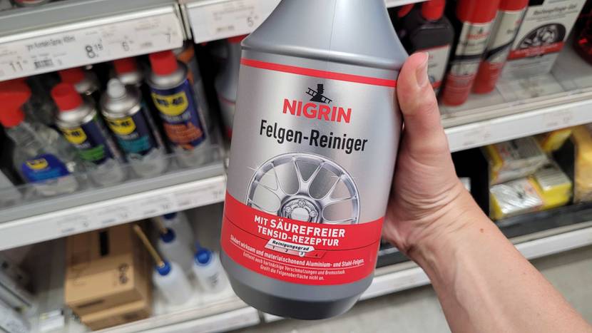 Felgenreiniger-Test: Eine Hand hält eine Flasche mit Nahansicht der Kurzbeschreibung auf der Vorderseite.