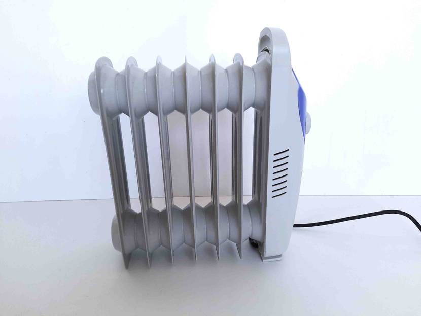 Ölradiator getestet: Ein Gerät von der Seite mit Stromkabel vor einer hellen Wand.