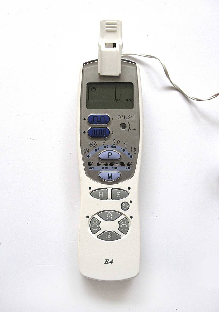 Im Test: Das Reizstromgerät mit Programmwahl und LCD-Display liegt verkabelt auf einer weißen Oberfläche.