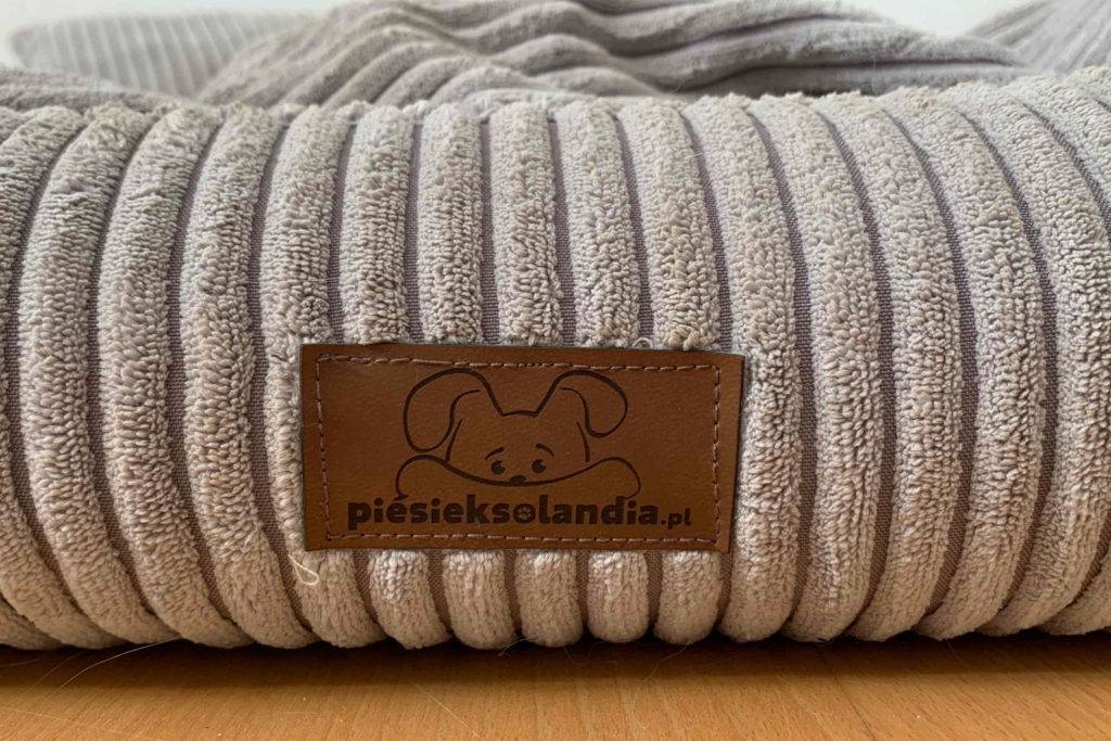 Stoffbezug eines piesieksolandi Hundebetts in Rippenoptik mit Hersteller-Einnäher.