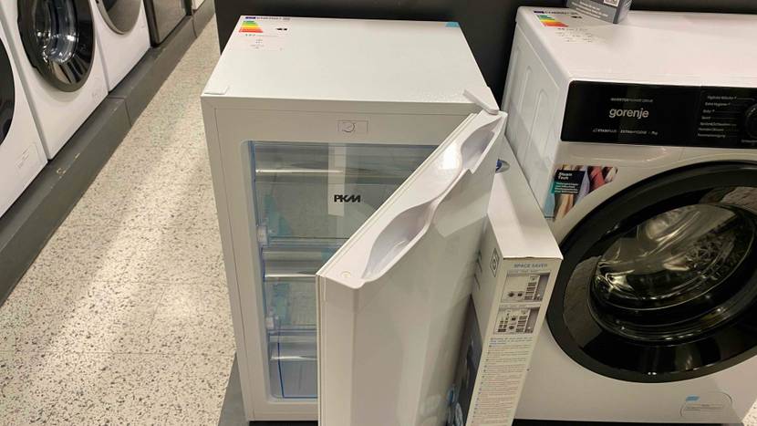 Im Test: Ein Gefrierschrank von schräg oben mit geöffneter Tür neben einer Waschmaschine in einer Verkaufsfläche.