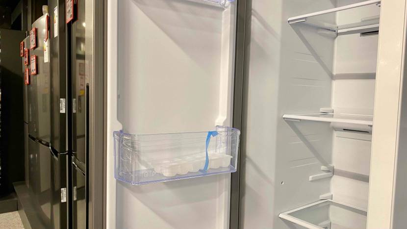 Side-by-Side-Kühlschrank-Test: Detailaufnahme einer geöffneten Tür und des Innenraums inklusive Glasflächen und Türfach eines silberfarbenen Kühlschranks.