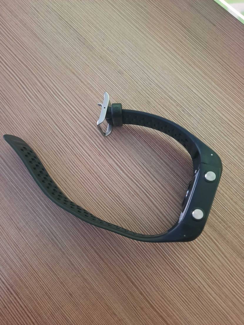 Eine getestetete Polar-Pulsuhr liegt auf der Seite auf einem Holztisch.