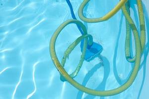 manueller poolsauger mit schlauch in einem pool