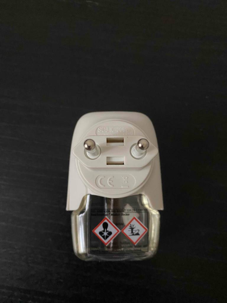 Blick von oben auf einen getesteten Mückenstecker, auf dem Warnhinweise angebracht sind.