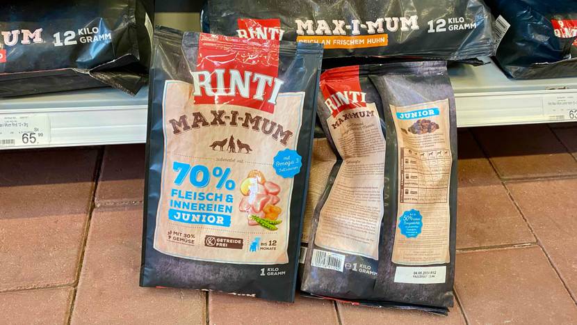 Zwei 1-kg-Packungen Rinti Welpenfutter im Test stehen vor einem Verkaufsregal mit Hundefutter.