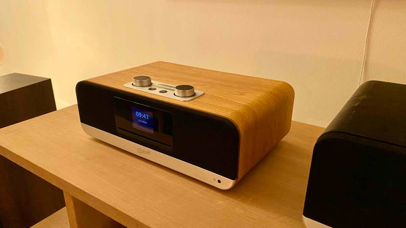 Im Test: Ein Internetradio auf einem Holztisch neben Boxen.
