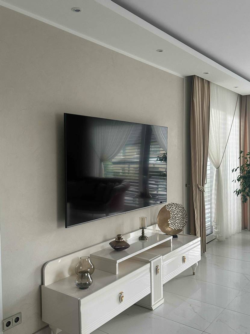 80-Zoll-Fernseher im Test: Blick von schräg vorn auf ein an der Wand angebrachtes Gerät.