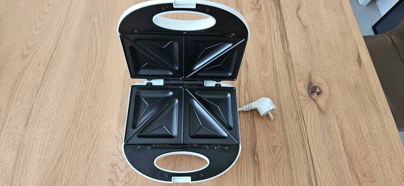 Ein getesteter Sandwichmaker geöffnet von schräg oben auf einem Holztisch.