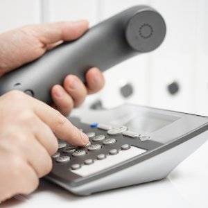 mann waehlt auf schnurtelefon