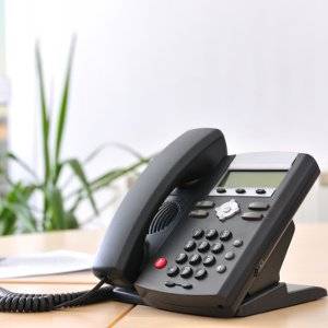 schwarzes schnurtelefon auf schreibtisch