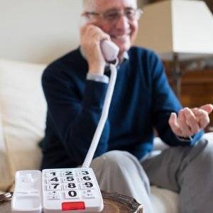 aelterer mann nutzt seniorentelefon