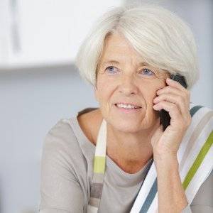 aeltere dame telefoniert in der kueche