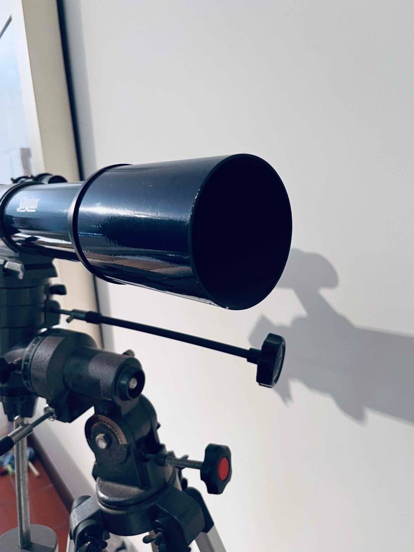 Detailansicht von einem Fernrohr eines getesteten Teleskops inklusive Stativ vor weißem Hintergrund.