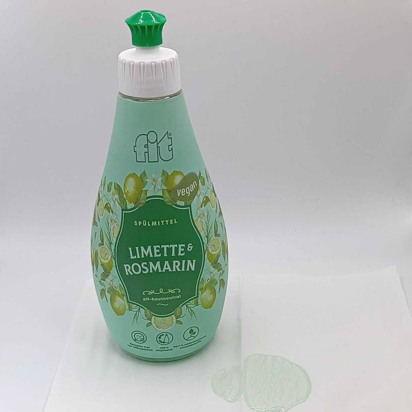 Offene Spülmittelflasche mit ausgeschüttetem Spülmittel.